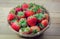 Strawberrys berries in a basket on the wooden floor.