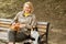 Stray cats sit on park bench near young Caucasian woman