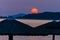 Stray sunshades at beach with orange sunset in background, Sithonia