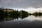 Strbske pleso, lake and small town, in the evening. Buildings and trees reflecting in the lake. High Tatras, Slovakia