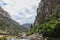 Stream beside built up highway through towering cliffs of Rocky Mountains