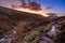 Stream and footpath in Mourne Mountains valley at golden hour and dramatic sunset