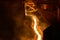 A stream of hot metal, molten steel flowing along a guide chute.