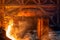 A stream of hot metal, molten steel flowing along a guide chute.