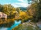 A stream between the mountains of the Pyrenees runs through a riverside forest