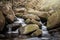 Stream running through rocks waterfall. Longe exposure motion blur tranquil Peak District outdoors river stones