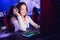 Streamer beautiful girl professional gamer smile laughs playing online games computer with headphones, red and blue