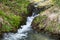 Streaming water, flowing through the rocks of a mountain alpine stream brook,