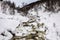 A streaming winter river in the mountains of Setesdal, Norway. River is surrounded by trees, snow and ice