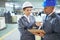 Streamlining shipping logistics on the factory floor. two managers in workwear talking together over a clipboard while