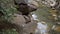 Streams of pure mountain water flow over the stones of the waterfall