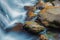 Streams of water over stones and autumn leaves Ularsky waterfall