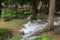 Streams of water pouring down onto limestone rocks under shades of trees at Kroeng Krawia Waterfall,Khao Laem National Park,Sangkh