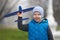 Streat portrait of the preschool boy launching a plane