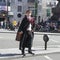 Street actor portraying Harry Potter, stands on the dividing line, crossing a road