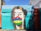 Street art, Port Louis, Mauritius. Four colored face mask with the colours of the Mauritian flag, red, blue, yellow, green.