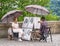 Street artist on Charles bridge making a sketch or a portrait to a woman sitting on a chair