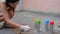 Street artist, close-up spray cans in different colors, young woman hands with aerosol paint in slow motion