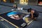 Street artist drawing the Girl with a Pearl Earring on asphalt