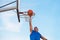 Street basketball athlete performing slam dunk on the court