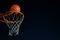 Street basketball ball falling into the hoop at night. Urban youth game. Close up of orange ball above the hoop net. Concept of