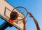 Street basketball slam dunk competition. Close up of ball falling into the hoop. Urban youth game. Concept of success, scoring