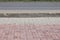 A street border painted in white and black on the background of the road and green foliage in the summer closeup. Road