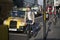 Street Brick lane at noon in the backlight. People hurry about their business. A man riding a bicycle on the road. East London