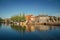 Street and bridge over the canal, moored boats and brick houses at sunset in Weesp.