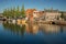 Street and bridge over the canal, moored boats and brick houses at sunset in Weesp.