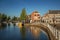 Street and bridge over the canal, moored boats and brick houses at sunset in Weesp.