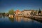 Street and bridge over the canal, moored boats and brick houses at sunset in Weesp.