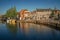 Street and bridge over the canal, moored boats and brick houses at sunset in Weesp.