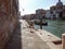 Street on canal in Venice, Italy. Dirt and garbage