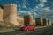 Street with cars in front towers on the wall around Avila