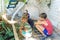 Street children sit in the trash in the corner of an abandoned house. Staged photo