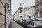 Street in the city center of St. Petersburg, cars parked along the road, old buildings in classic style, the dome of St. Isaac`s