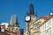 Street clock on a pillar against the background of the tower in Prague