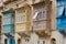 Street with colourful traditional wooden maltese balconies in Sliema, Malta