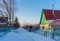 Street in country village covered with snow and left for the winter brick cottage house on wintery evening at sunset. Russian