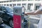 Street electric filling station for electric car refueling. Eco-friendly mode of transport. A person inserts a cord or