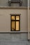 Street exterior view with beige wall and window frame with lamp yellow light from inside vertical outdoor photo