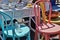 Street Fail Garage Sale Vintage Antique Dishes on Wicker Desk next to Colorful Wooden Brightly Painted Chairs