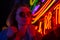 Street fashion young girl with sunglasses, neon light red blue, nightlife and trendy lifestyle