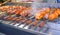 Street food. Automatic stainless steel grill grills skewers on skewers. Fried meat. Cooking street food