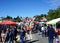 A street full of peoples and kids that walking around during the festival on a a beautiful sunny day