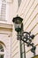 Street hanging lamp with a beautiful bracket in the wall of a multi-storey building.