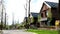 A street with houses and manicured lawns in a typical American suburb. A frame of small brown brick American country houses