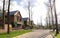 A street with houses and manicured lawns in a typical suburb. Frame made of small brown brick American country houses. Ukraine,