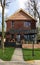 A street with houses and manicured lawns in a typical suburb. Frame made of small brown brick American country houses. Ukraine,